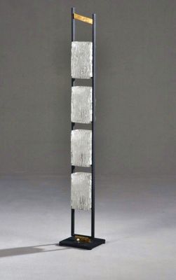 a tall metal and glass sculpture with a wooden base