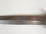 a large metal knife that is laying on a table