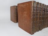 several old books are stacked on top of each other on a white surface
