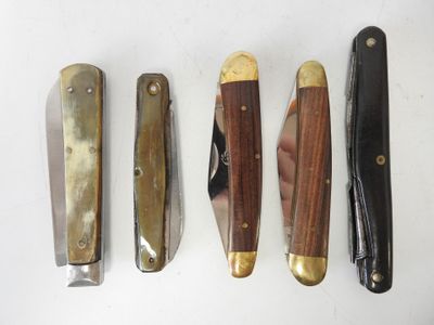 several different types of knives are lined up on a white surface