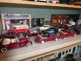 Plusieurs petites voitures sont alignées sur une étagère dans un magasin de jouets