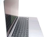 a silver laptop with a black keyboard on a white surface