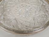 a clear glass plate with a silver rim on a table