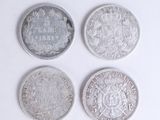 quatre types différents de pièces d'argent sur une surface blanche