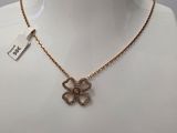 un collier en or orné d'un pendentif en forme de nœud, porté par un mannequin