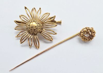 broche en forme de fleur de couleur dorée sur fond blanc