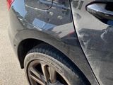 a car that has been dented and is parked in a parking lot