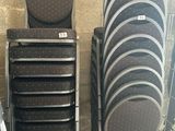 Plusieurs chaises empilables sont empilées sur une palette dans un entrepôt