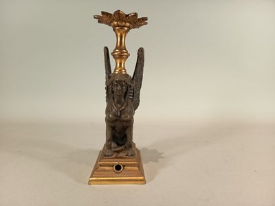 a gold candle holder with a bird on it