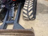 a tractor that is sitting on the ground next to a skid steer