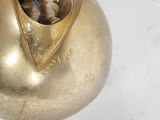a gold vase that has a small figurine inside of it