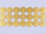 gros plan d'une pile de pièces d'or sur une surface blanche