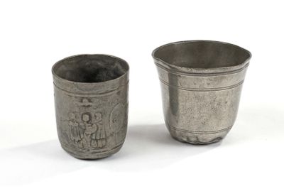 two silver cups sitting next to each other on a white surface