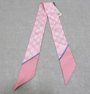 a close up of a pink and blue tie on a gray surface