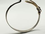 a close up of a silver cuff with a snake on it