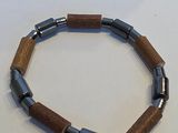 bracelet composé de perles en bois et en métal sur un fond blanc