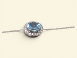 une photo d'un collier orné d'une topaze bleue entourée de diamants blancs
