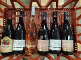 six bottles of wine sitting in a basket on a table