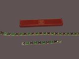 two bracelets and a red box on a gray surface