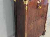 a wooden cabinet with a marble top on wheels