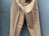 un pantalon beige suspendu à une corde à linge devant un mur bleu