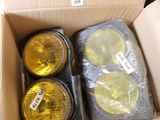 four yellow lights in a cardboard box on a table