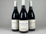 trois bouteilles de vin rouge posées sur une table