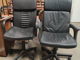 pair of black leather office chairs in a warehouse area