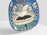 a blue plate with a bird on it on a stand