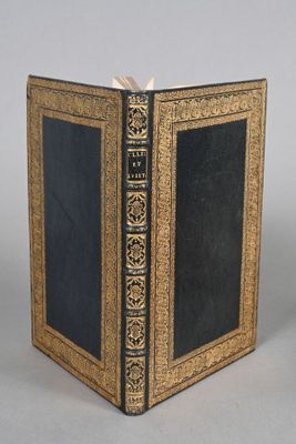 un vieux livre à la couverture noire posé sur une table