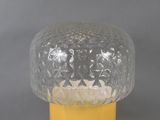 a glass vase with a yellow base on a table