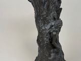 a sculpture of a tree trunk with a bird perched on it