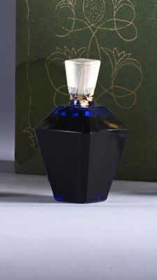 an image of a bottle of perfume sitting on a table next to a box