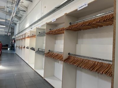 beaucoup de vêtements suspendus aux portants du magasin