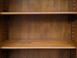 a wooden bookcase with three shelves and two doors