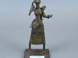 statue en bronze représentant une femme tenant un bébé dans ses bras, posée sur un socle
