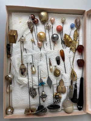 une boîte contenant de nombreux types de broches et d'épingles