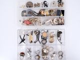 une boîte transparente remplie d'un assortiment de bijoux en argent et en or