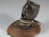 a sculpture of a man ' s head on top of a basket