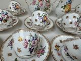 a lot of tea cups and saucers sitting on a table