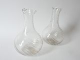 pair of clear glass vases sitting on a white surface