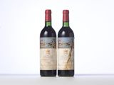 two bottles of red wine sitting on top of a table