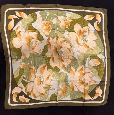 un gros plan d'un foulard carré orné de fleurs et de feuilles