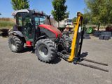 un tracteur équipé d'une fourche, garé sur un parking