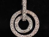 un gros plan d'un pendentif en diamant posé sur une surface noire