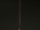 un collier plaqué or sur lequel est représentée une femme