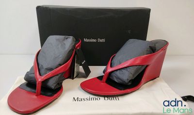 the red and black sandals are next to a black box