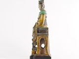 a statue of a woman sitting on top of a tower