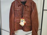 une veste en cuir marron suspendue à un portant dans un magasin