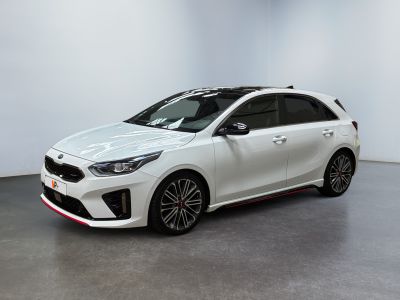 a white car is parked in a room with a white wall